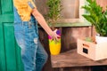 Girl in dungarees holding colorful pots on porch