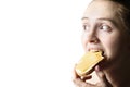 Girl eagerly eats a sandwich with cheese and butter. Close-up. Isolate on white background. Copy space