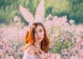 Girl easter bunny with creative ears on the hoop. Portrait of a young, red-haired woman with big beautiful eyes and lips Royalty Free Stock Photo