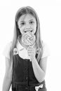 Girl eat lollipop isolated on white. Little child enjoy candy on stick. Happy kid smile with swirl caramel. Candyshop
