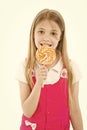 Girl eat lollipop on white. Little child enjoy candy on stick. Happy kid smile with swirl caramel. Candyshop