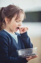 The girl eating blueberries from a glass bowl Royalty Free Stock Photo