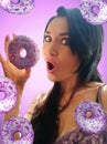 Girl eating blueberry freshly donut against lilac background around donuts. unhealthy concept