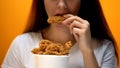 Girl eating chicken wings, high calorie food and health risks, cholesterol Royalty Free Stock Photo
