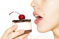 Girl eating chocolate cake with cherry on the top icing Royalty Free Stock Photo