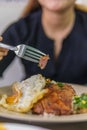 Vietnamese girl eating Com tam - a Vietnamese broken rice with pickles steak grilled pork ribs cucumber onion oil sweet chilies Royalty Free Stock Photo