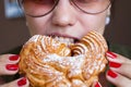 Girl is eating a custard ring - a traditional Russian dessert