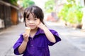 Girl are eating ice cream cone on hot evening after school. Cute Asian child with sweet smile looking at camera. Royalty Free Stock Photo