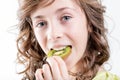 Girl eating a kiwi slice