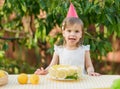 girl eating lemon Birthday cake. Lemonade birthday party at summer park. food, celebration and festive concept