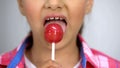 Girl eating lollypop, happy childhood concept, teeth health, diabetes risk