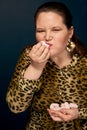 Girl eating marshmallows. Leopard blouse. Overweight. Portrait of a fat girl.