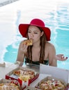 Girl eating pizza best relax in the hotel pool