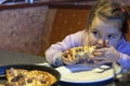 Girl eating pizza in restaurant