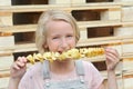 Girl eating potato chips on a stick. Junk food, street food, snack on a walk.