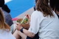 Girl Eating a Quick Meal Sitting Outside: Mixed Salad