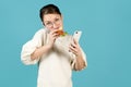 Girl eating a sandwich while talking on the phone and holding phone in her hand Royalty Free Stock Photo