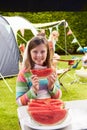 Girl Eating Watermelon Whilst On Family Camping Holiday