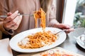 Girl eats Italian pasta with tomato, meat. Close-up spaghetti Bolognese wind it around a fork with a spoon. Parmesan Royalty Free Stock Photo