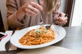 Girl eats Italian pasta with tomato, meat. Close-up spaghetti Bolognese wind it around a fork with a spoon. Parmesan Royalty Free Stock Photo