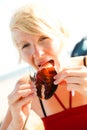 Girl eats lobster claw Royalty Free Stock Photo