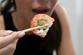 A girl eats salmon sushi with chopsticks. Japanese delicious cuisine Royalty Free Stock Photo