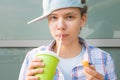 Girl eats shrimp in batter and drinks a drink while sitting at the table