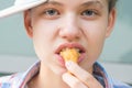 Girl eats shrimp in batter, front view, close-up