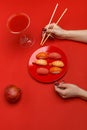 The girl eats sushi on a red plate. Creative concept of restaurant table setting