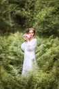 girl on the edge of the forest in a long white dress