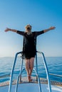 A girl on the edge of a yacht waves her arms Royalty Free Stock Photo