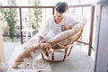 Girl with elegant white manicure stroking beagle dog while enjoying coffee in morning. Gorgeous young lady in summer