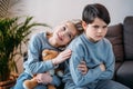 Girl embracing offended boy sitting on sofa at home Royalty Free Stock Photo