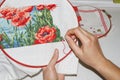 Girl is embroidering picture close up. Hands, needle, thread and embroidery. Hobby house with own hands. Hand-made products.