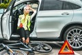 Girl in emergency vest in the car drinks beer. the bike lies on the asphalt Royalty Free Stock Photo