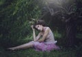 Girl enchanted Princess with horns sitting under a tree. Girl Mystical creature fawn in shabby clothes in a fairy forest