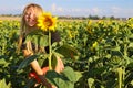 Girl in a field of blooming sunflowers in nature. Happy, perky and cheerful