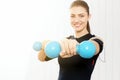 The girl is engaged with blue dumbbells.