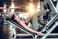 Girl is engaged in fitness workout with simulator leg press at gym Royalty Free Stock Photo