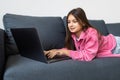 Girl engaged on laptop while lying the sofa in room at home. Concept education is process teaching at school. Teenager studying Royalty Free Stock Photo