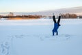 girl is engaged in outdoor sports in early winter morning. Teenage girl does handstand in the snow.