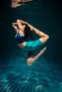 The girl is engaged in yoga under the water in sports clothes. Asanas and Meditation