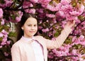 Girl enjoying cherry blossom or sakura. Cute child enjoy nature on spring day. Aromatic blossom concept. Girl tourist