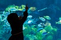 Girl enjoying at fishs in the aquarium