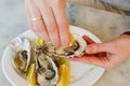 Girl enjoying gourmet delicacy with oysters, lemons, and silver utensils at outdoor dining event