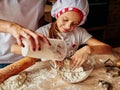 Girl enjoying kneading the dough in the kitchen. Kids at the kitchen. Family housekeeping Royalty Free Stock Photo