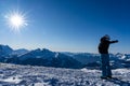 Girl enjoying sunbeams in winter with open arms at top of the mountain range Royalty Free Stock Photo