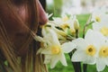 Girl enjoys the aroma of a bouquet of daffodils