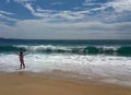 The girl enjoys the Atlantic ocean and the waves in the city of Nazare in Portugal.