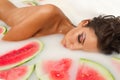 Girl enjoys a bath with milk and watermelon.